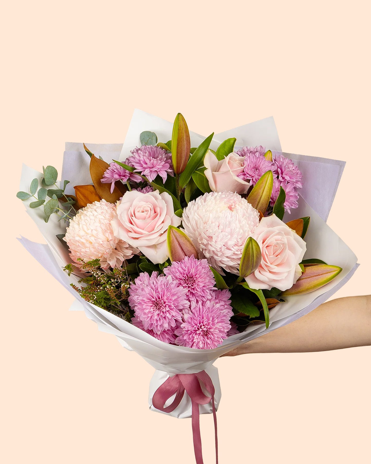 Blushing Beauty bouquet of soft pink roses, chrysanthemums and lily buds in a white wrap with a dusty pink ribbon
